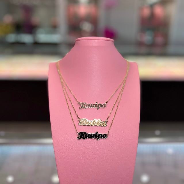 Layered script name necklaces in gold and black enamel